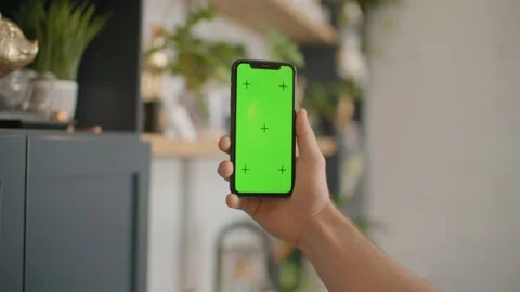 Man pulls up iphone into frame, green screen mockup, kitchen 库存影片 218466968
