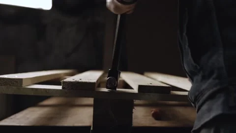 A man pulls nails out of planks with the help of claw hammer. dismantling a w Stock Footage 166334826