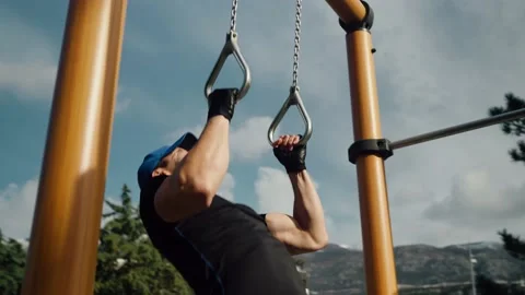 A man pulls up on the Olympic rings on the street Stock Footage 239201036