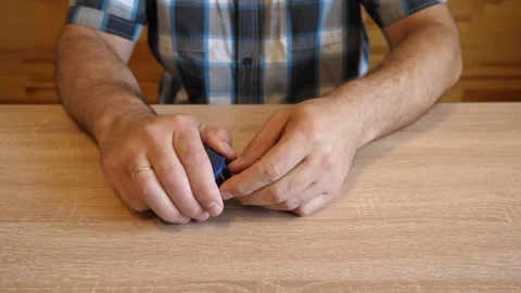 A man pulls out and releases the tape of a construction measuring tape. The v Stock Footage 341254536