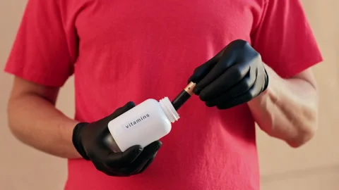 A man pulls out a battery from a white jar labeled "vitamins" Stock Footage 141819334