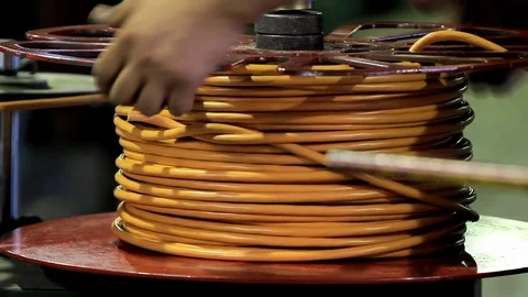 Man pulls out a coiled orange cable Video stock 76951050