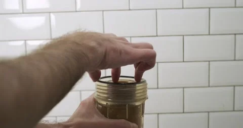 Man pulls out a dirty water pre-filter cartridge. Cartridge replacement concept Vidéo 225153367