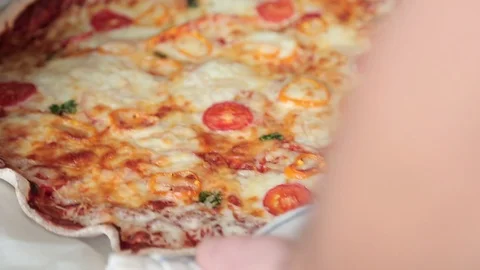The man pulls out the finished pizza from the oven Video stock 86462400