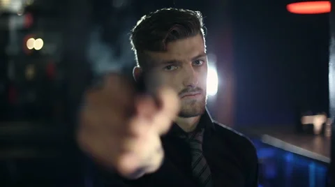The man pulls out a gun and aims at the viewer Stock Footage 43888907