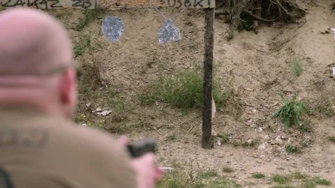 The man pulls out a gun from his holster. shooting practice. shooting range. 스톡 동영상 217353816