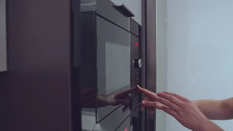 Man pulls out a plate of food from the fridge and puts in the microwave for a Stock Footage 163378730
