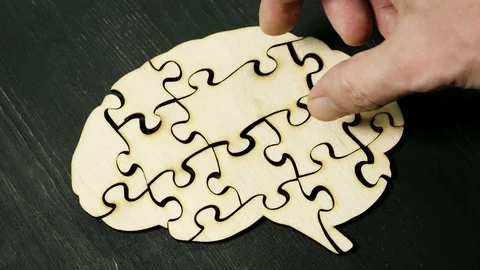 A man pulls out puzzles from a brain model. Memory problems and psychological. Stock Footage 121840609