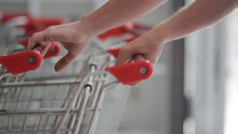  man pulls out a supermarket cart and advances Stock Footage 123799871