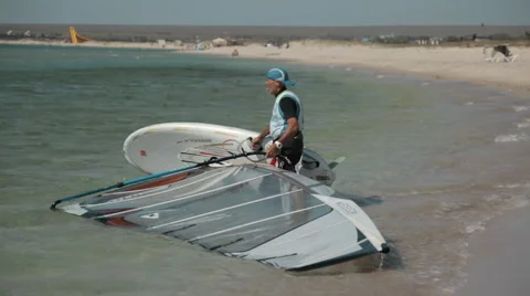 Man Pulls Out Windsurfing of the Water to Shore Video stock 61261288