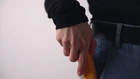 Man pulls out a yellow clerical knife from his jeans pocket. Stock Footage 142778394