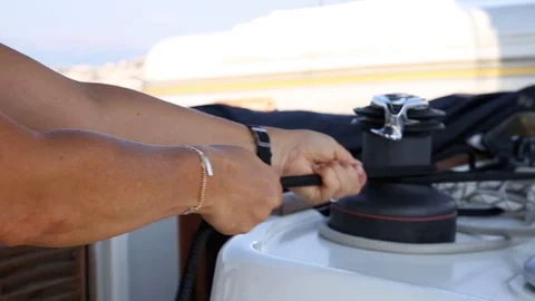 Man pulls on rope to hoist the sail of a boat Stock Footage 117117318