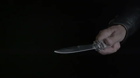 MAN PULLS A STILETTO KNIFE IN HIS RIGHT HAND.  ECU IN 4K. Stock Footage 203343320