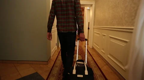 The man pulls a suitcase in hotel Stock Footage 60702574