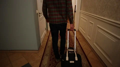 The man pulls a suitcase in hotel Stock Footage 60702624