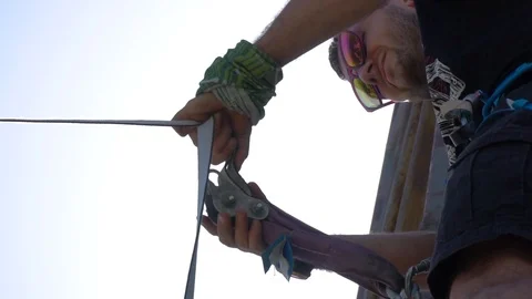 A man pulls a Tightrope for a highline pulley, line lock Stock Footage 89796282