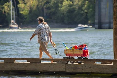 Man pulls a wagon on dock Stock Photos