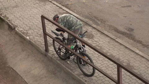 A man with a pump is trying to inflate the rear wheel of his bicycle Video stock 157229213