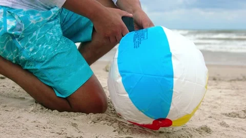 Man Pumping the ball on the beach Stock Footage 140784259