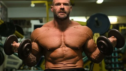 Man pumping up biceps muscles workout fitness and bodybuilding Video stock 119076938