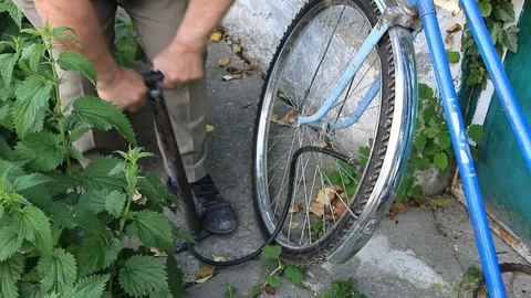 Man pumping a bicycle wheel with a pump Stock Footage 85671144