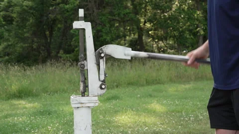 Man pumping fresh water into a large jug at a park Stock Footage 338119977