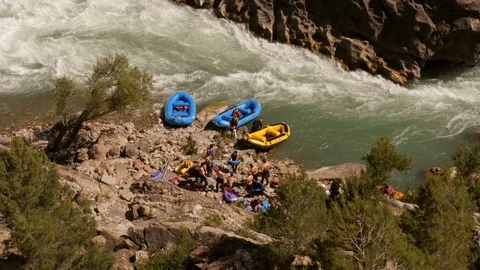 Man pumping up a raft at the river prior to start of  river rafting tour Stock Footage 98305762