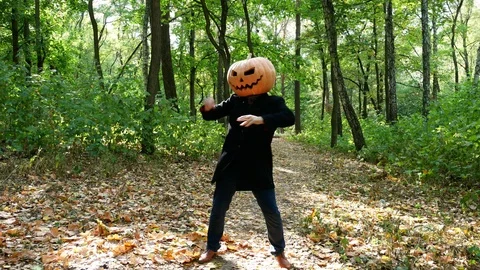 Man pumpkin head dancing in the forest, the sun shines brightly Stock Footage 116491466