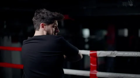 A man punches the camera with his hands and elbows. Shooting in a boxing ring Stock Footage 260682518