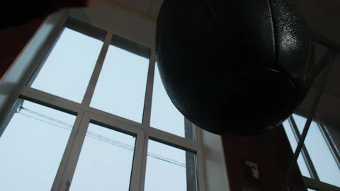 Man punches hanging bag practicing skills and concentration Stock Footage 306664133