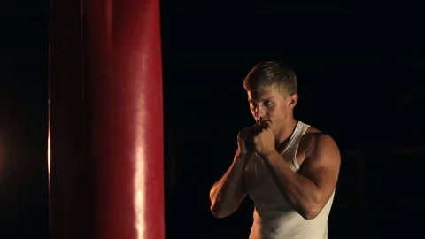 Man punching red boxing bag 스톡 동영상 77876577