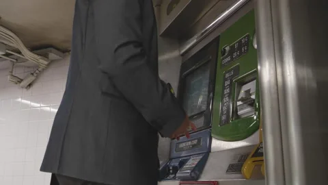 Man purchases train ticket from kiosk in busy urban station Stock Footage 312682463