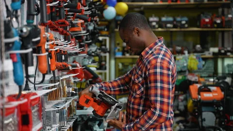A Man Purchasing a Circular Saw in a Hardware Store Stock Footage 295968704