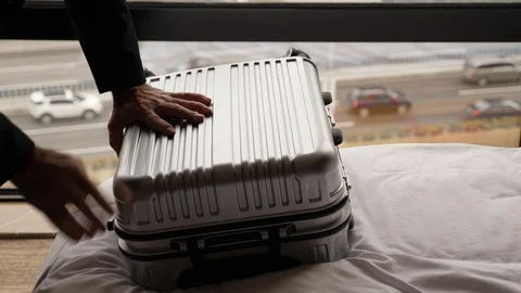 Man push on case to close it, finish packing stuff and ready to departure Video stock 103630427