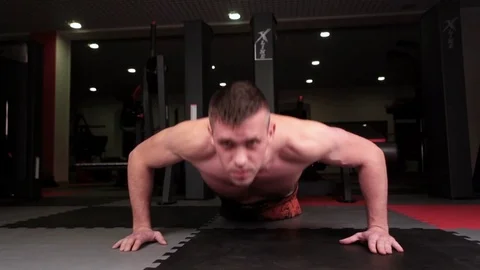 Man push up chest exercise and gritty serious facial expression inside gym Vídeos de archivo 72881507