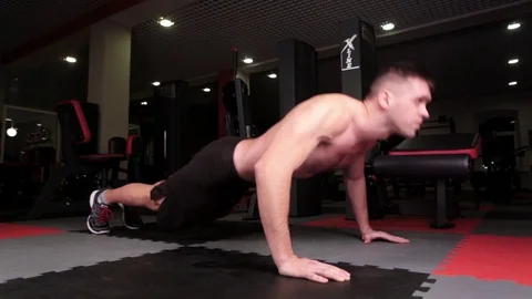 Man push up chest exercise and gritty serious facial expression inside gym Stock Footage 72881818