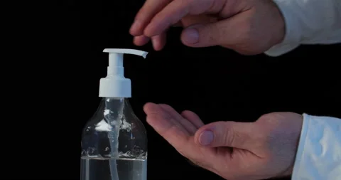 Man push dispenser and liquid soap squeezed out to hand, black background. Video stock 142235375