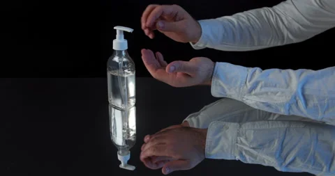 Man push dispenser and liquid soap squeezed out to hand, black background. Stock Footage 142235775