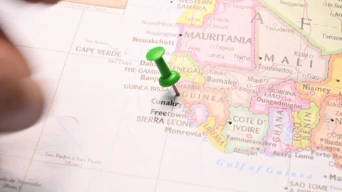 Man Push Pin Pointing On  Guinea On World Travel Map Stock Footage 328102676