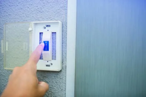 Man push the white exit button on electronic panel. staff push exit button to 스톡 사진