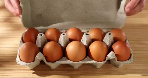 A man pushes and opens a package of Eggs. close-up. high angle view. Stock Footage 242854963