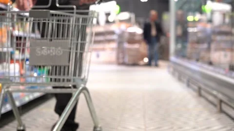 A man pushes an empty cart through the store. Chooses food. Stock Footage 166053128