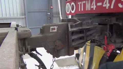 A man pushes with his foot the automatic coupler hitch on a train with a car for Stock Footage 138087582