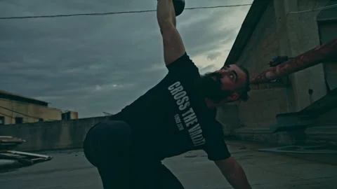 Man pushes kettlebell into air during workout outside Stock Footage 275593479