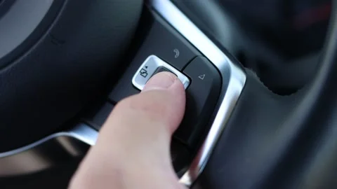 Man pushes the navigation buttons on the steering wheel of a car. Stock Footage 141842583