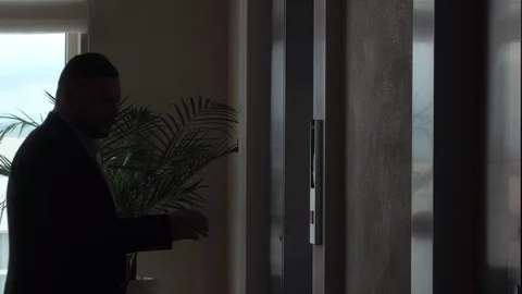 Man pushing button for calling elevator in apartment corridor and using mobile Stock Footage 98787049