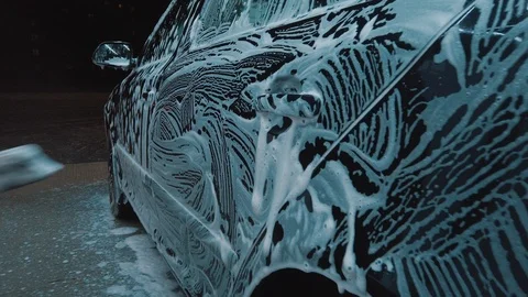 Man pushing a car surface with a dry rag outdoor at the evening. Cold weather. Stock-Footage 121852820