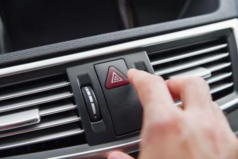 Man pushing emergency light button while driving car Stock Photos