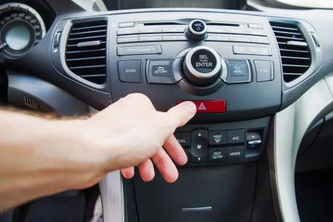 Man pushing emergency light button while driving car Stock Photos