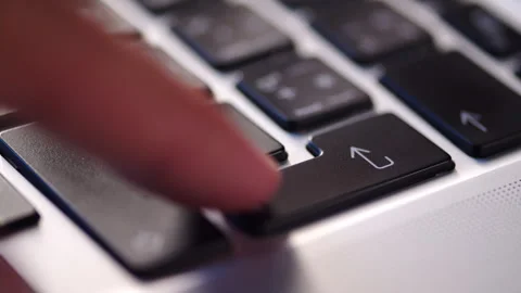 Man pushing the enter button on a black keyboard.  Pressing Enter key on a .. Stock Footage 340958248